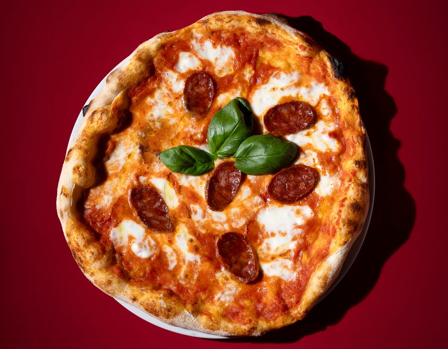 Una pizza al salame piccante con basilico.